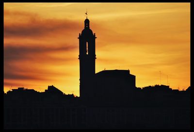 Silhouette of building against sky at sunset
