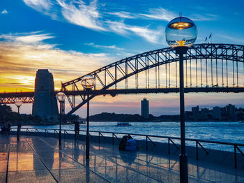 View of bridge over river at sunset