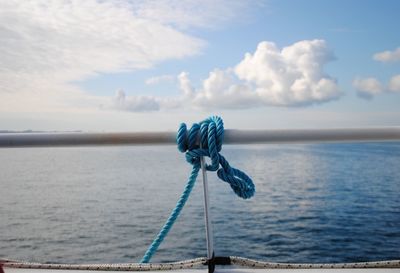 Close-up of rope tied to sea against sky
