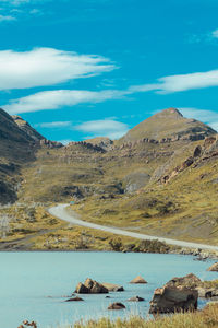 Scenic view of lake and mountains against blue sky