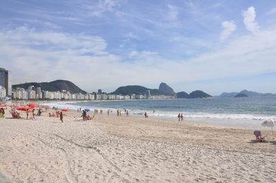 People on beach against sky