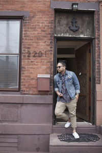 A young man on a doorstep.