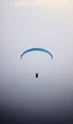 Person paragliding against sky