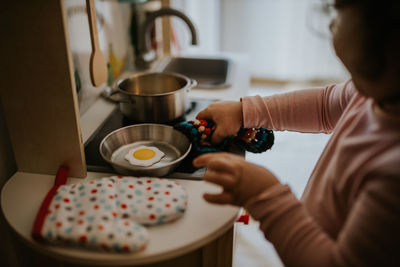 Midsection of girl preparing food at table