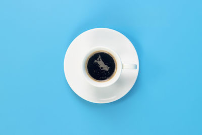 Directly above shot of coffee cup against blue background