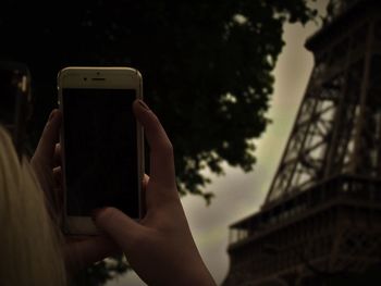 Cropped image of woman photographing through smart phone