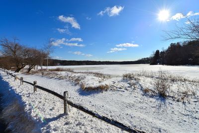 Scenic view of snow covered field against blue sky