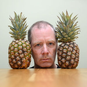 Portrait of man with fruits on table