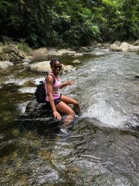 Full length of woman on rock in stream