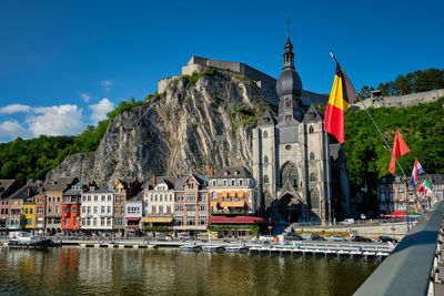 Buildings by river against sky