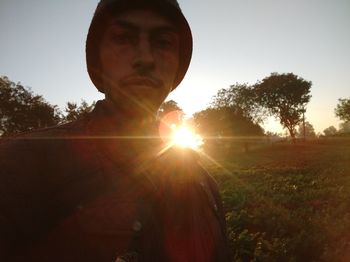 Portrait of man on field against sky during sunset