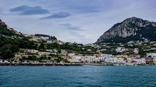 View of townscape by sea against sky