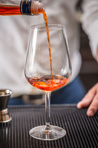 Close-up of wineglass pouring in glass