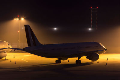 Airplane on airport runway at night