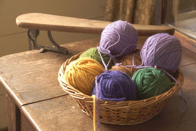 High angle view of colorful ball of wools in container on table