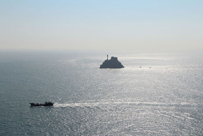 Silhouette boat sailing on sea against clear sky