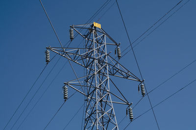 Low angle view of electricity pylon against sky