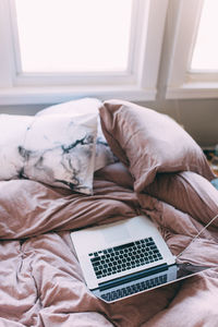 Close-up of laptop on bed at home