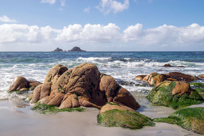 Scenic view of rocks on beach against sky