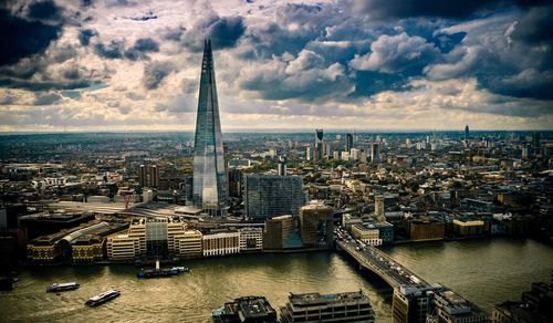 Aerial view of city against cloudy sky