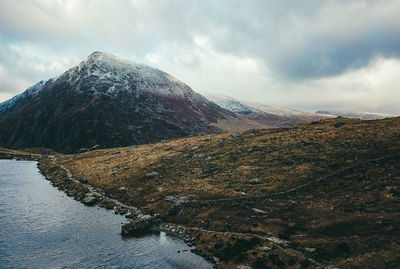 Scenic view of lake by mountains against sky