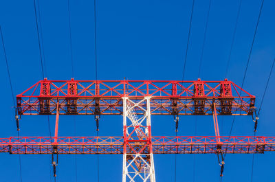 Low angle view of telephone pole against clear blue sky