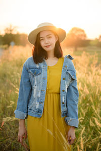 Portrait of a beautiful young woman standing on field