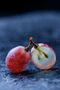 Close-up of frozen red grapes on table outdoors