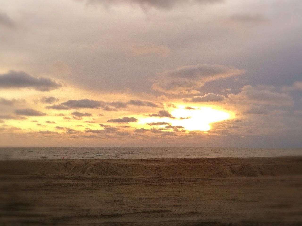 sunset, sky, tranquil scene, scenics, tranquility, sea, beach, beauty in nature, horizon over water, cloud - sky, sand, nature, shore, idyllic, water, cloud, orange color, sun, cloudy, remote