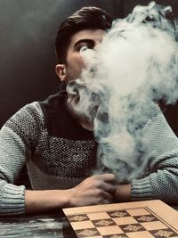 Portrait of young man smoking cigarette