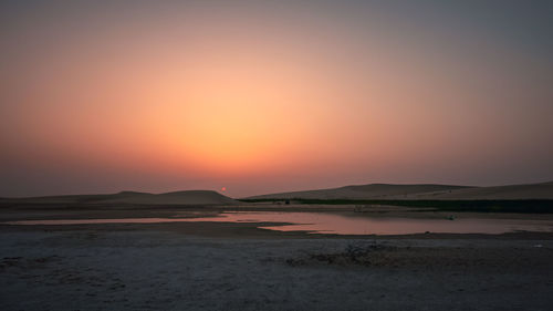 Scenic view of beach against sky during sunset