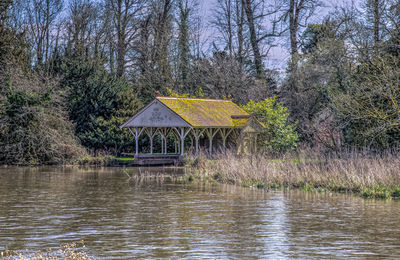 Built structure in lake against trees in forest