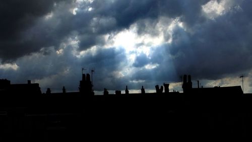 Low angle view of buildings against cloudy sky