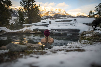 A woman enjoying an evening sunset in a hot spring.