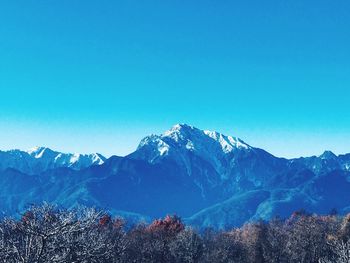 Scenic view of snowcapped mountains against clear blue sky