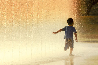Full length of boy jumping on beach