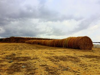 Hay bales on field against sky