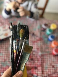 Close-up of hand holding paintbrushes