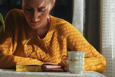 Close-up of young woman using mobile phone at home