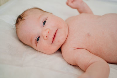 Portrait of baby boy lying on bed