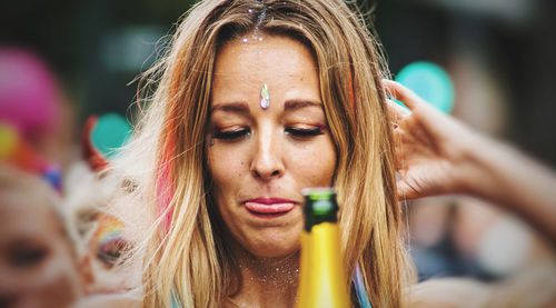 Close-up portrait of a young woman drinking glass