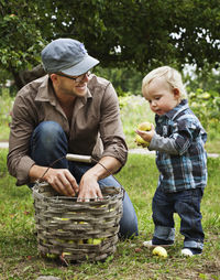 Father picking apples with his young son