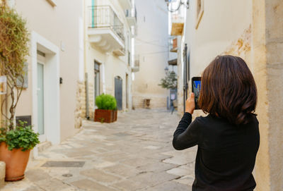 Side view of woman looking through window