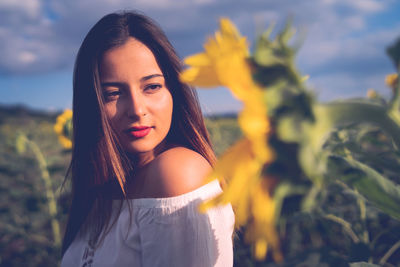 Teenage girl looking at sunflower