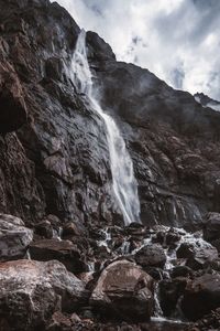 Low angle view of waterfall on rocks