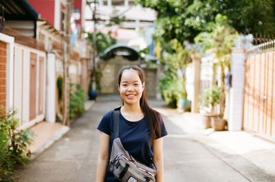 Portrait of a smiling woman standing against building