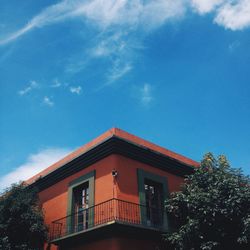 Low angle view of trees and house against sky