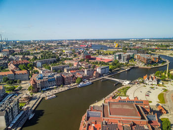 High angle view of river amidst buildings in city against clear sky