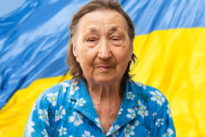 Portrait of senior woman against flag