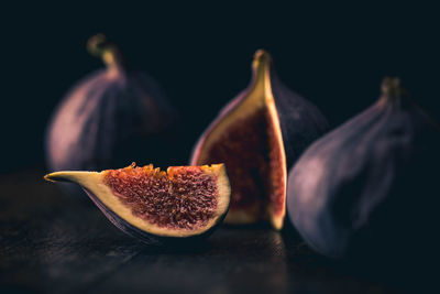 Close-up of fruits on table against black background